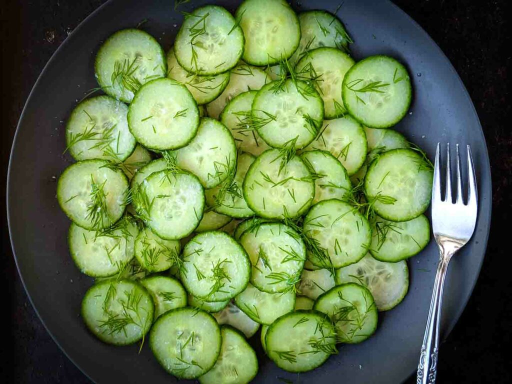 Finnish Cucumber Salad on a dark plate with fork