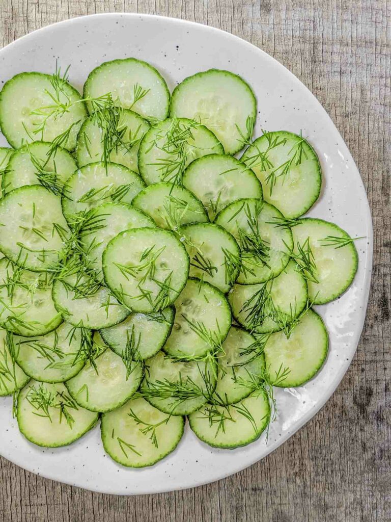 Finnish Cucumber Salad on a white plate and rustic background
