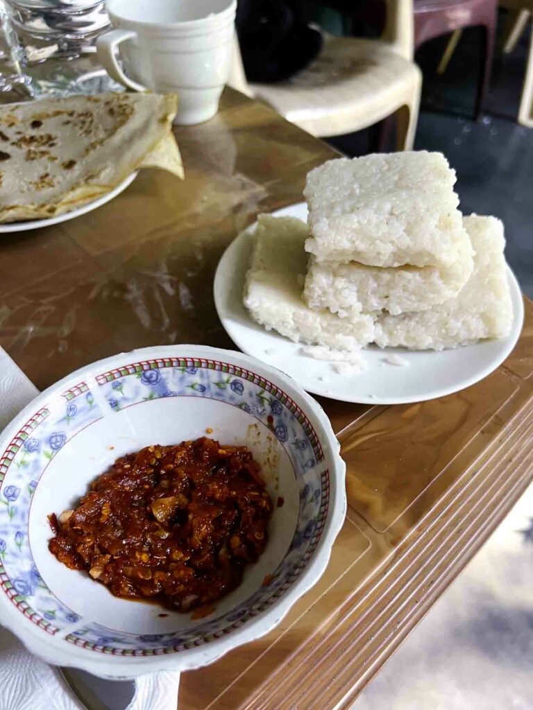 Kiri bath coconut rice squares with chili sambol on breakfast table