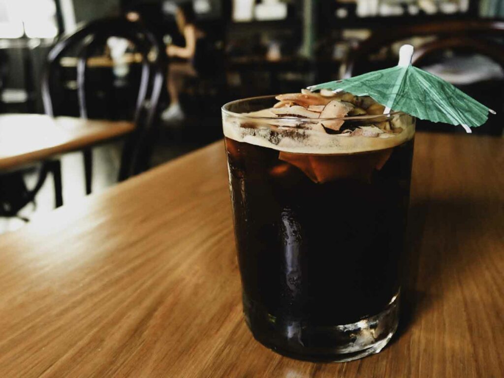 Ice coconut black coffee on table with umbrella at Sarnies Cafe in Bangrak Bangkok