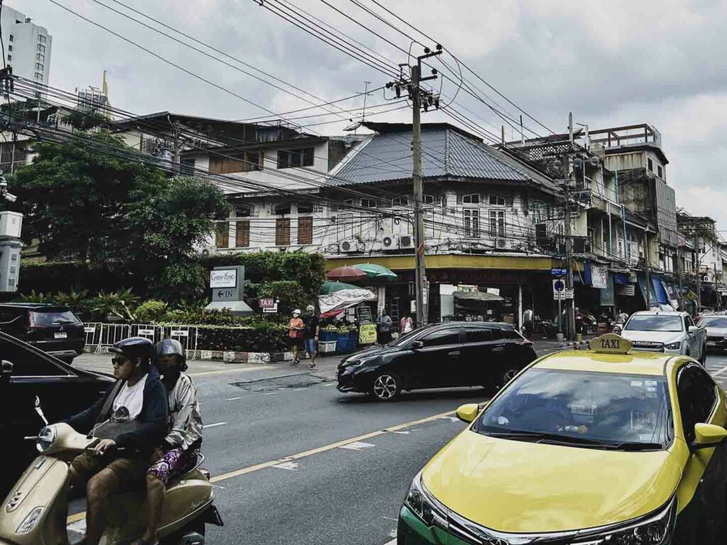 Traffic on Charoen Krung Road, main street in Bangrak neighborhood with cars, taxis and scooters