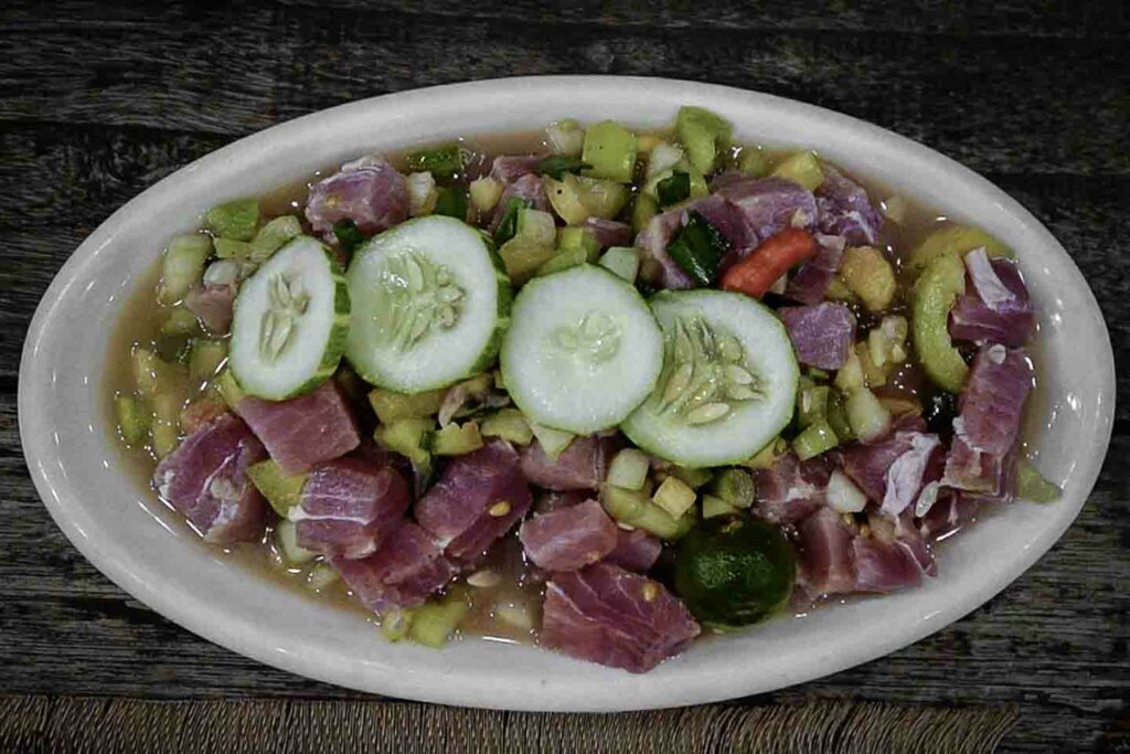 Filipino kinilaw on white plate on wooden table