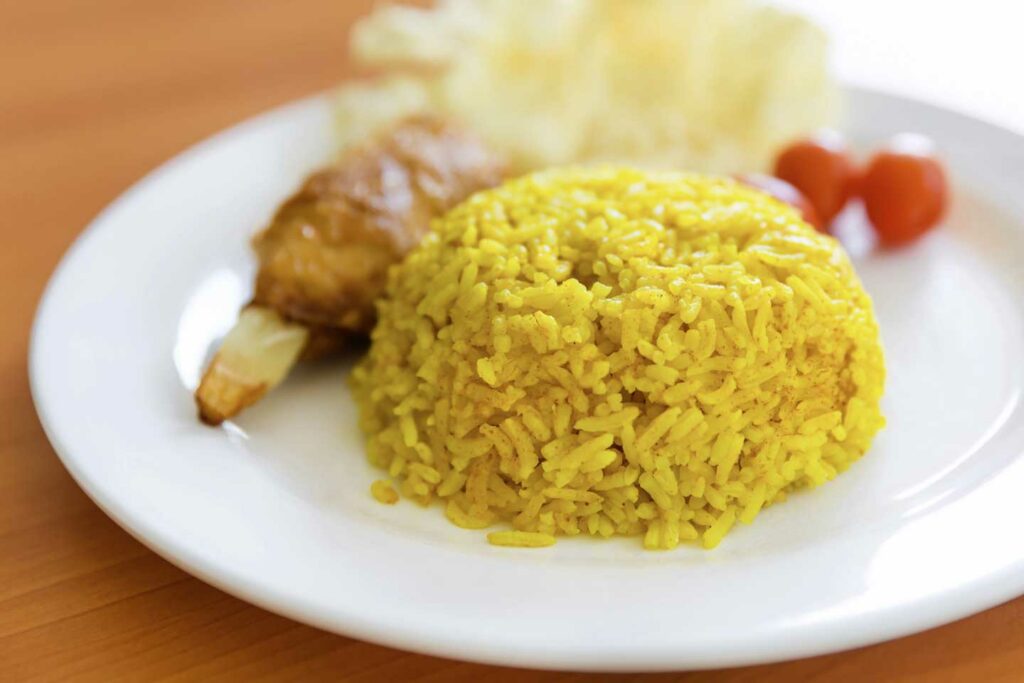 Kuning or yellow rice on a white plate, a popular side dish and Filipino Muslim food that originally came from Sulawesi in Indonesia although the recipe has changed