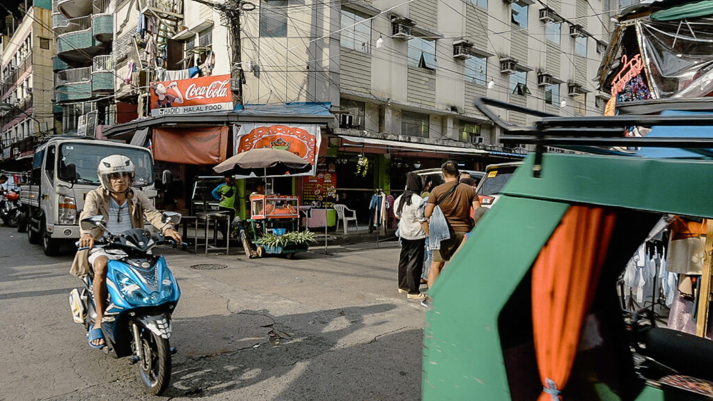 Street scene from Manila's Muslim town with traditional buildings and man on scooter