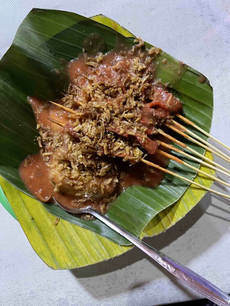 Satti, traditional grilled meat popular muslim food in Philippines served on banana leaf with side of compressed rice