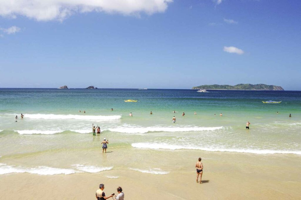 People on Nacpan Beach in Palawan and in the ocean