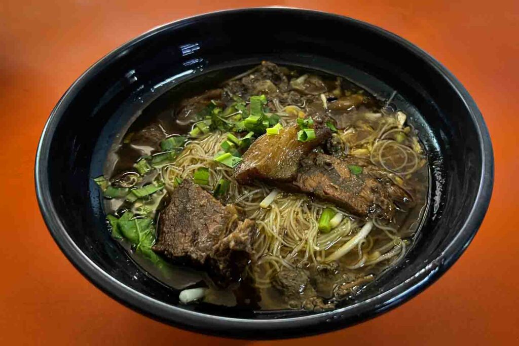 Michelin Selected beef noodle soup from Ayutthaya on orange table