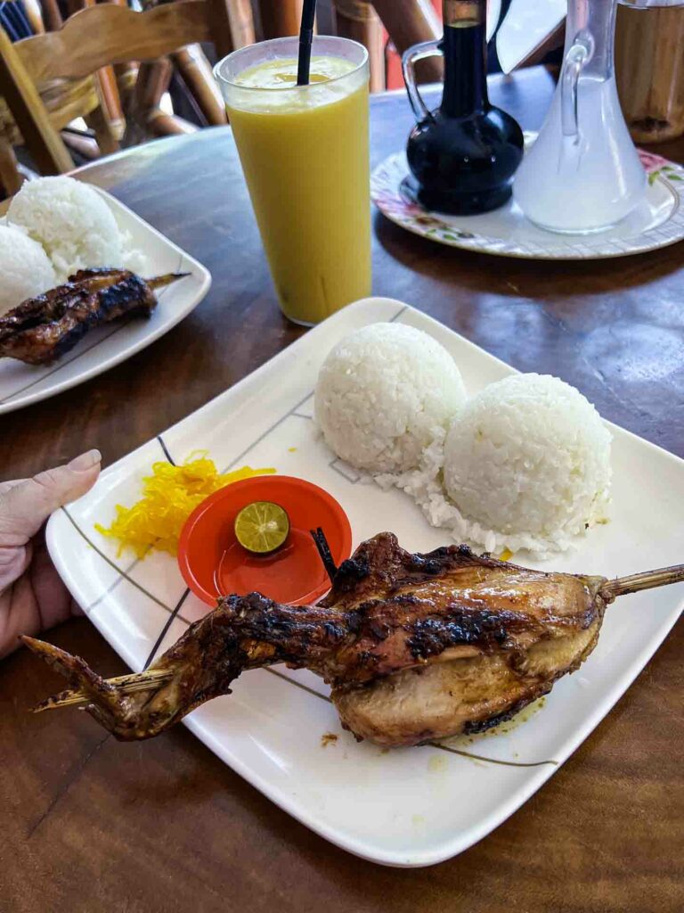 Filipino lechon manok at restaurant served with rice and pickled papaya