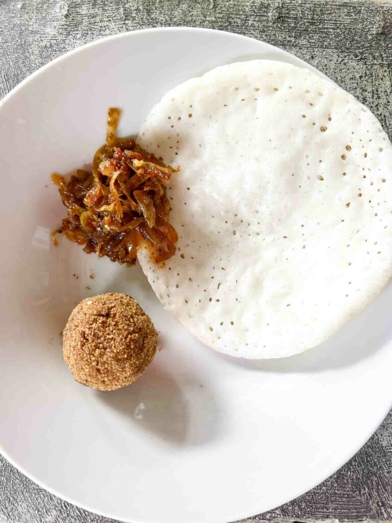 milk dosa and jackfruit polo with sambol on white plate and rustic background at Hela Bojun Hala in Kandy