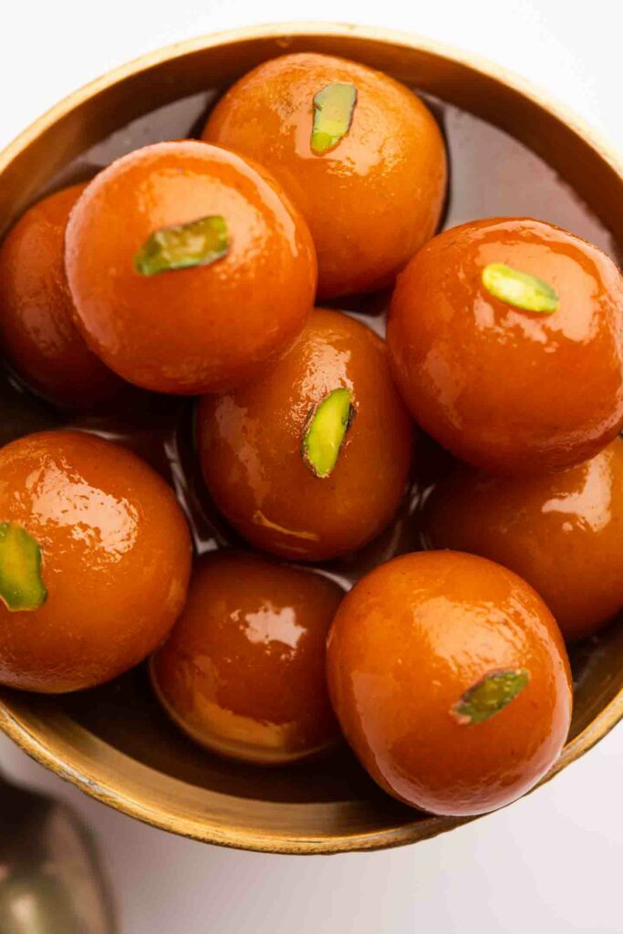 Little India singapore dessert Gulab Jamun in a round ceramic bowl and topped with pistachio