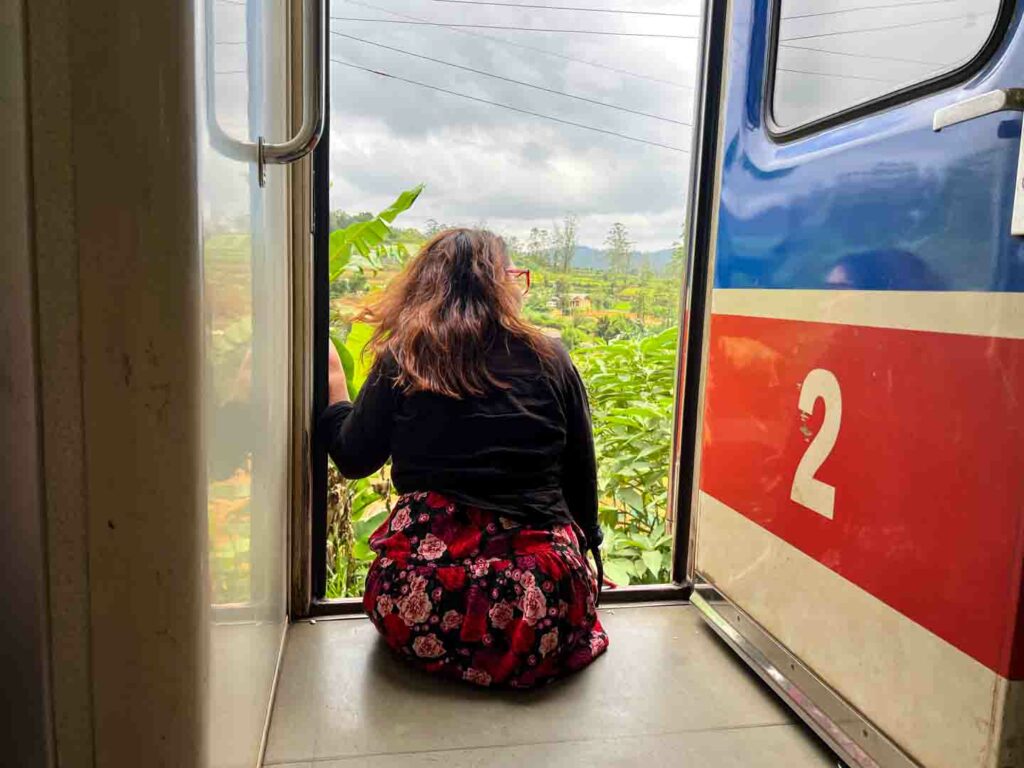 Woman looking out of train door between Ella and Kandy